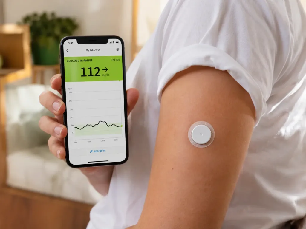 CGM Systems Compared: Which Continuous Glucose Monitor Is Right for You? (2026 Guide) 2 Person wearing a CGM sensor on arm